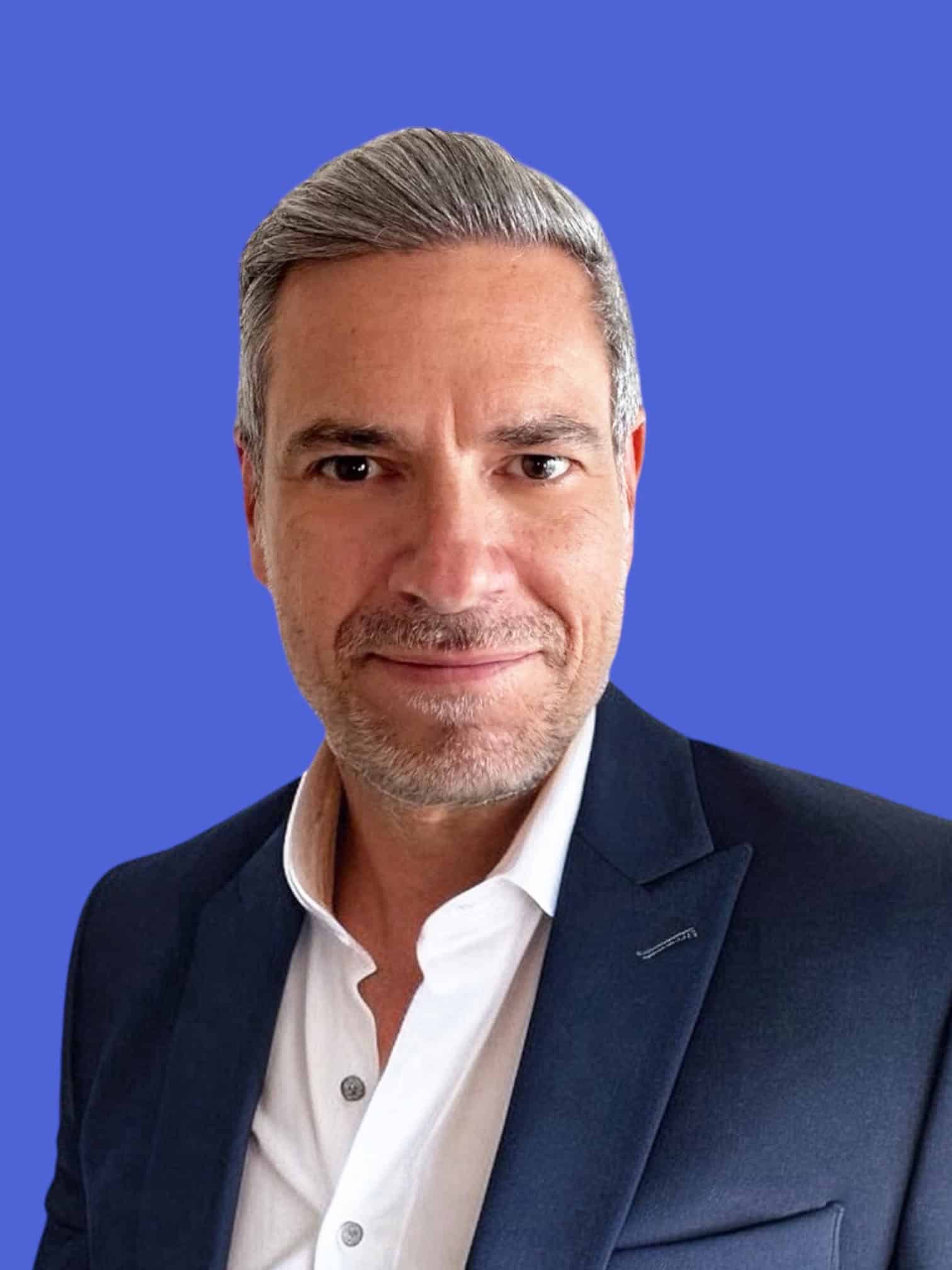 Professional business man in navy suit and white shirt, smiling confidently, representing Vega Global Group, a global logistics and supply chain management company.